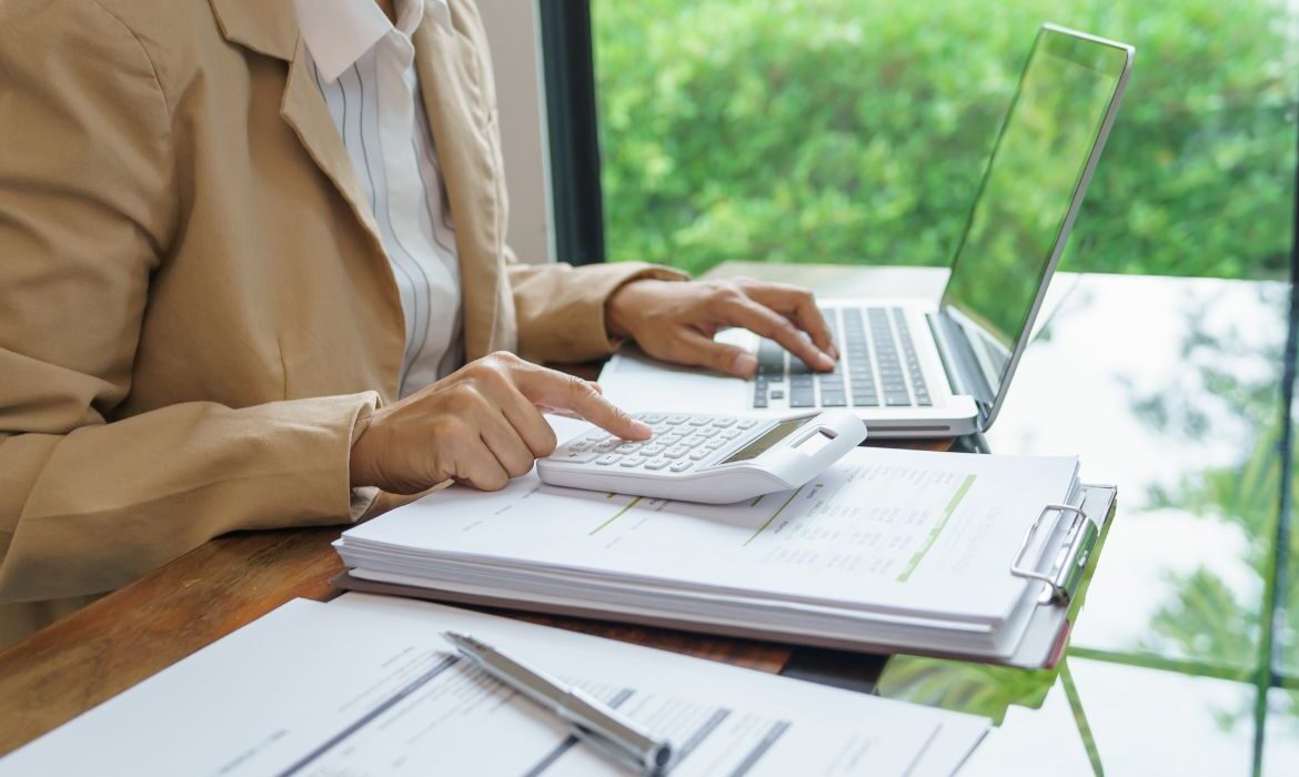 woman using a laptop and calculator