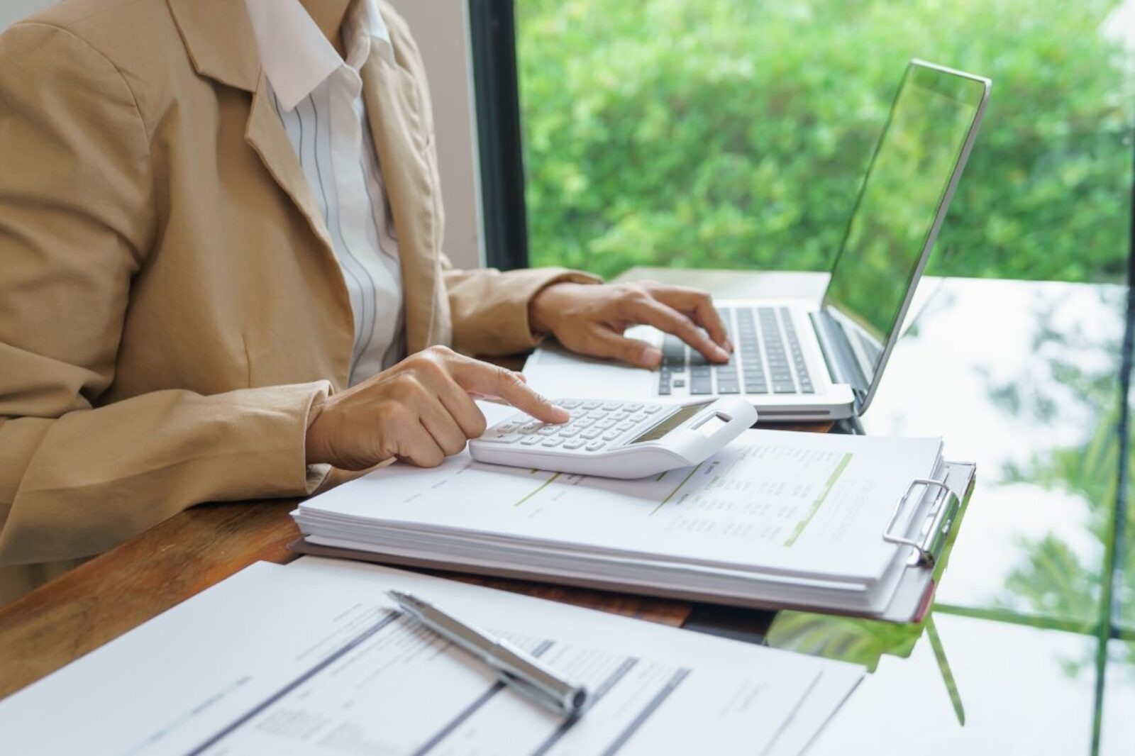 woman using a laptop and calculator