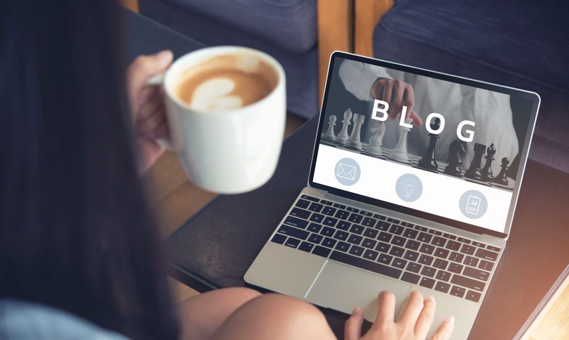 open laptop with the word "blog" on the screen and a cup of coffee
