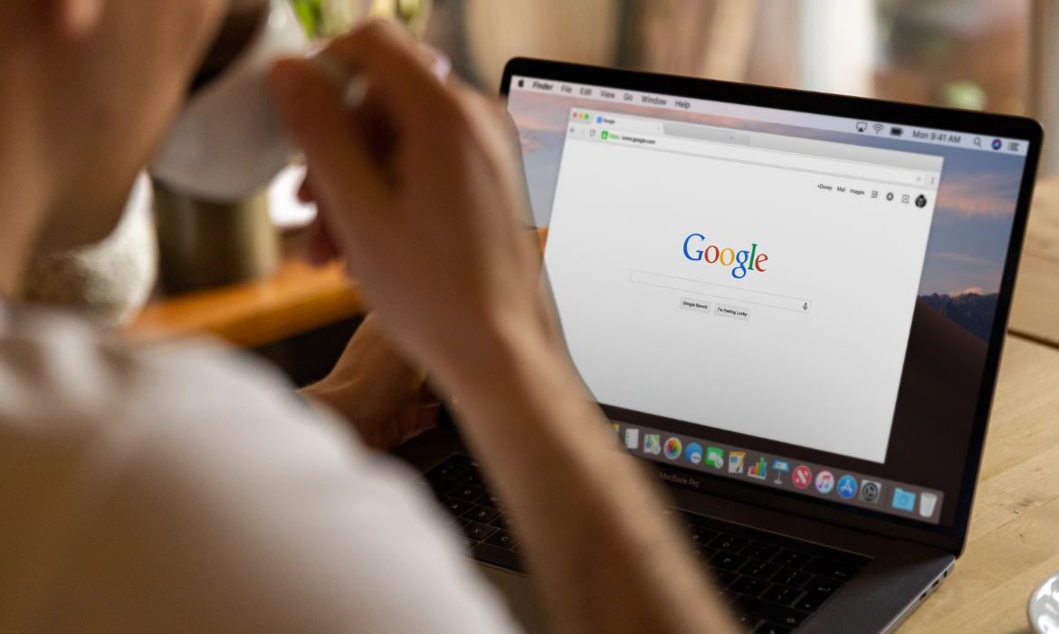 person searching on Google and drinking coffee